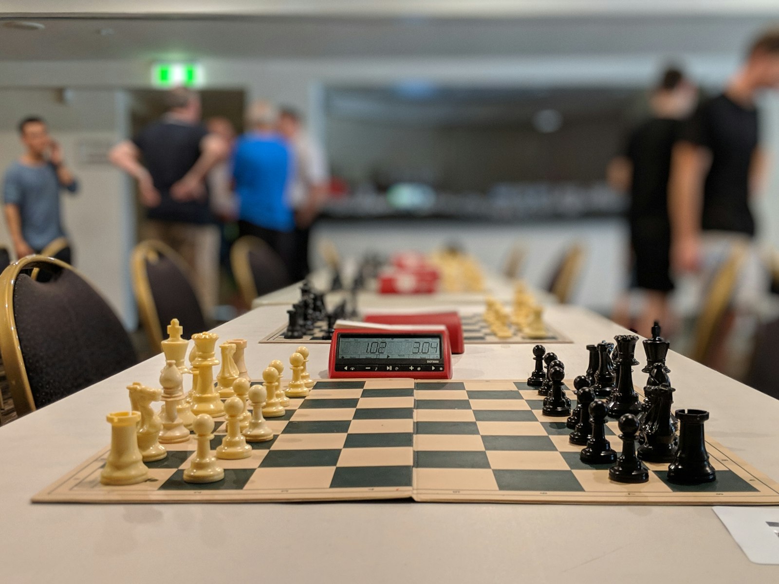 Chess boards with digital clocks set up in rows at a rated tournament venue