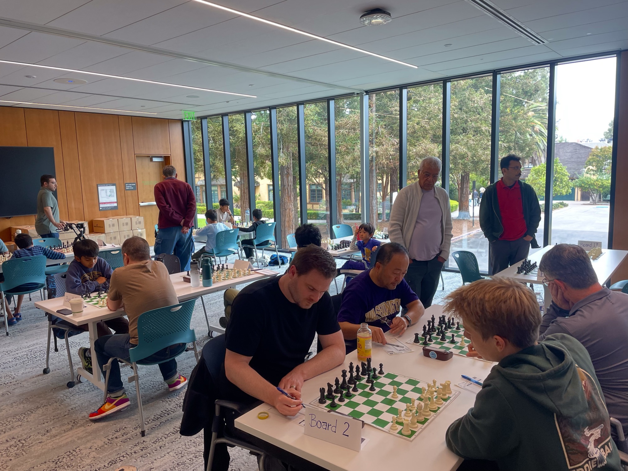 Players of different ages sharing tables at a Campbell chess event