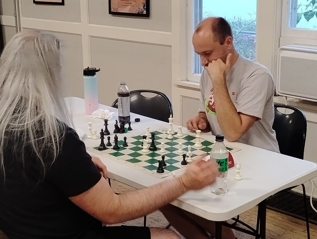 Two Spokane Chess Club members playing across a chessboard.